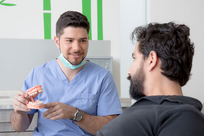 The doctor and the patient are talking about the root canal treatment in Cancun.