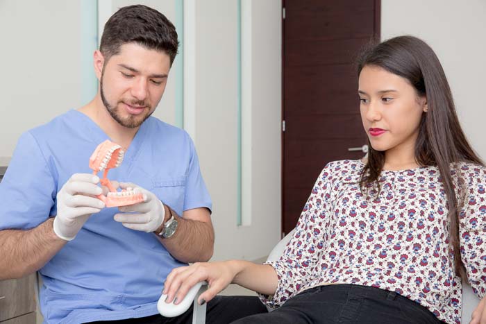 The root canal specialist is talking to the patient about the treatment in Cancun.